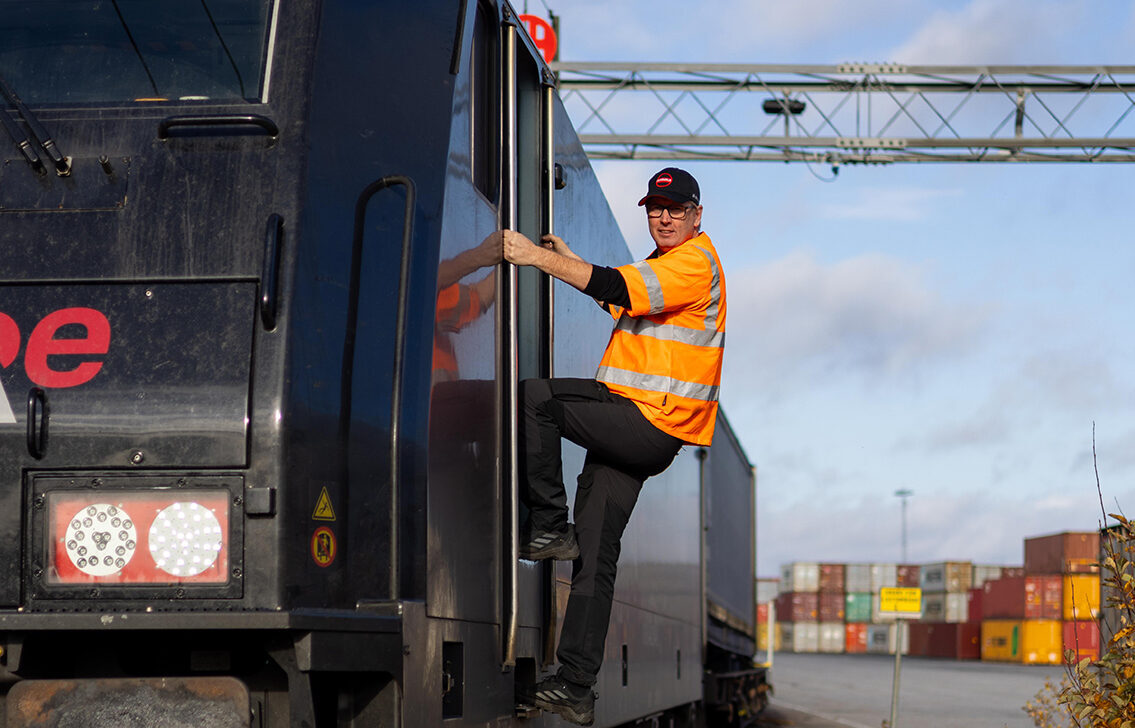 tågchaufför klättrar ur lok